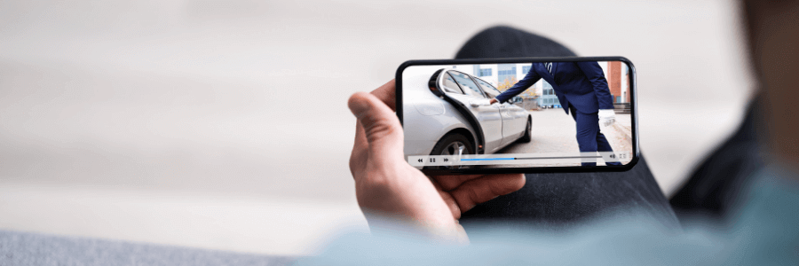 Image of someone looking at a luxury car video on a mobile phone