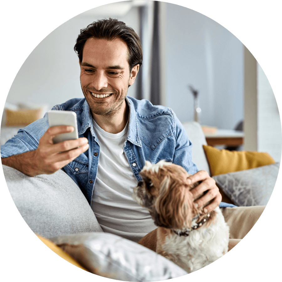 Person reading personalised SMS text message with dog next to him.